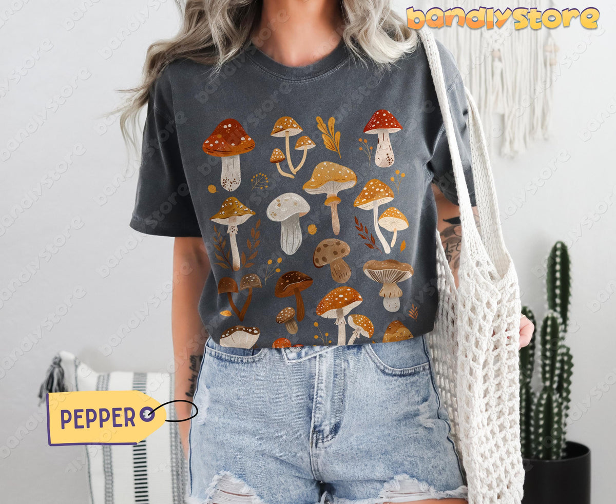Cute Mushrooms T-Shirt in Pepper, front view on a person with crochet bag, cactus and macrame nearby.