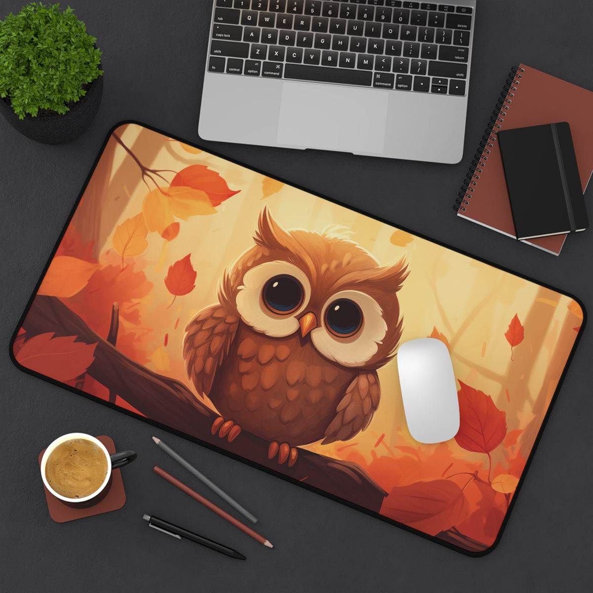 Cute Owl Desk Mat 12 × 22 inches in overhead view on a desk with laptop, plant, notebooks, coffee, pens and mouse.