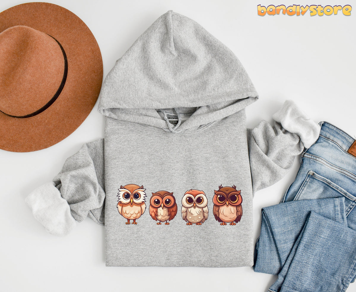 Cute Owl Hoodie in Sport Grey laid flat overhead beside a brown hat and blue jeans.