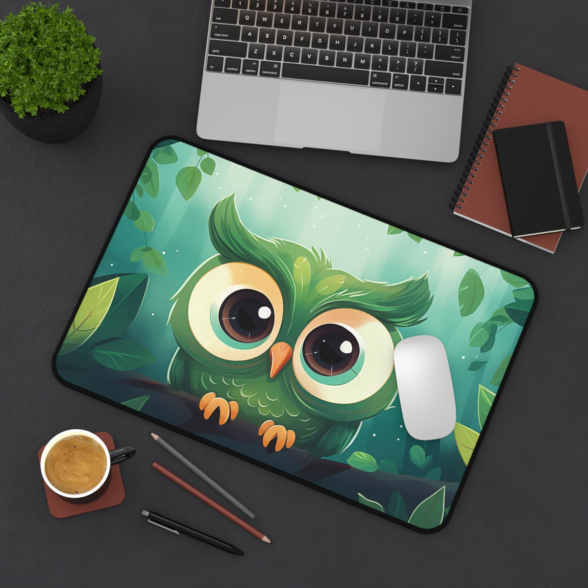 Cute Owl Desk Mat 12 × 18 inches viewed from above on a desk with laptop, plant, coffee, pencils, notebooks and mouse.