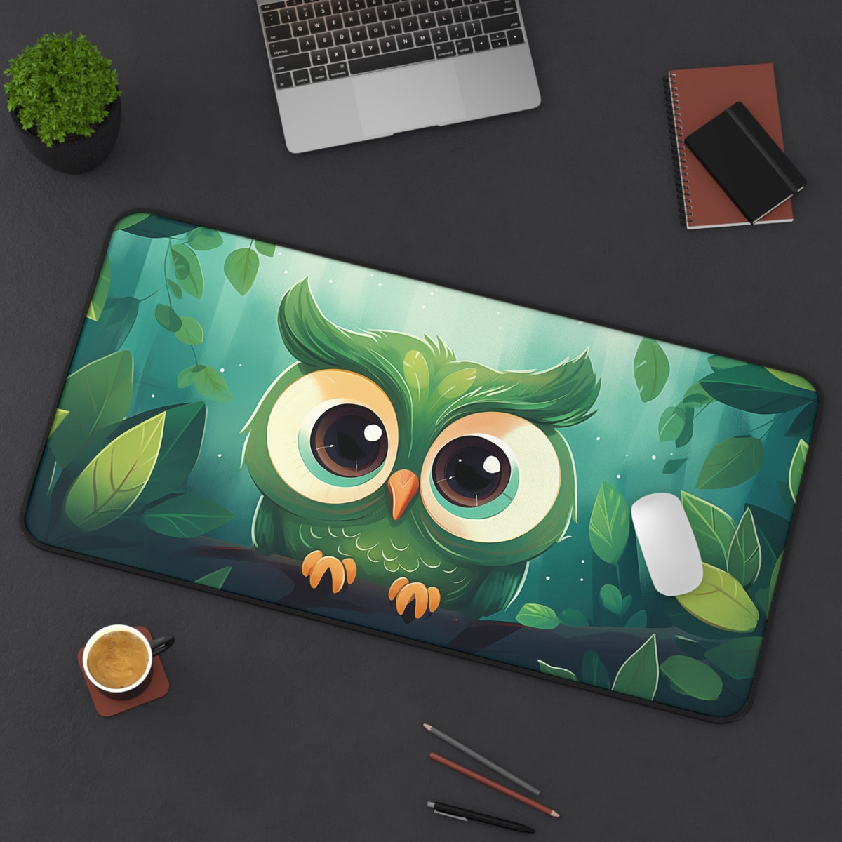 Cute Owl Desk Mat 16 × 32 inches in a top-down view on a desk with laptop, plant, notebooks, coffee cup and pencils.