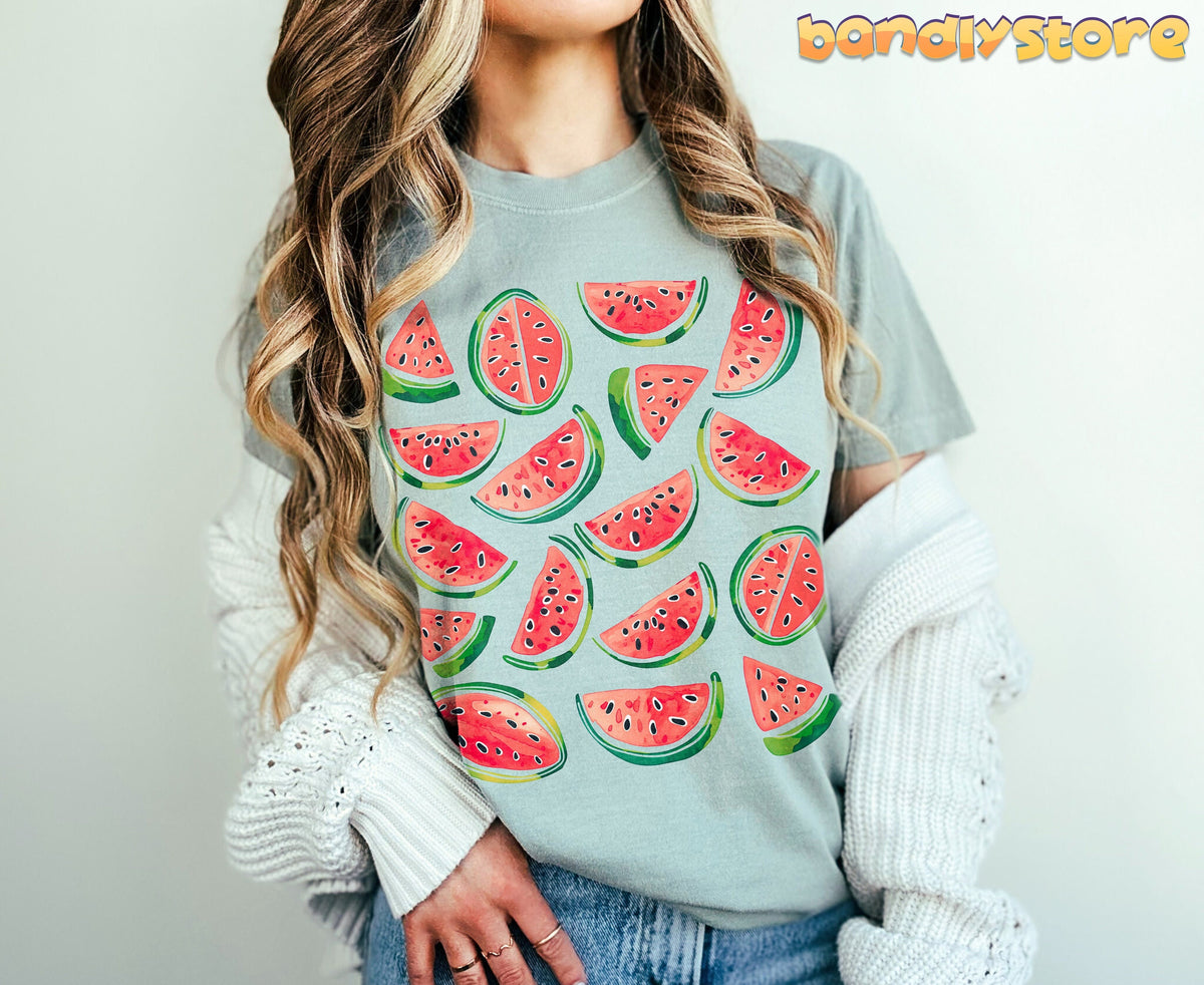 Cute Watermelon T-Shirt in Bay on a person facing forward with long wavy hair, draped sweater, jeans, plain background.