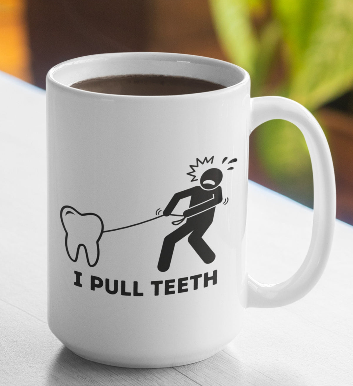 I Pull Teeth Dentist Mug front-facing on a wooden table with blurred foliage in the background.