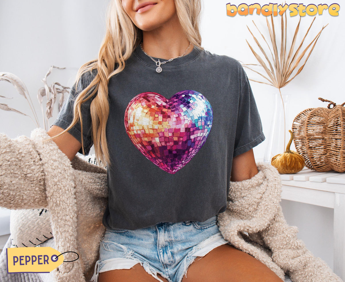 Disco Ball Heart T-Shirt in Pepper, worn front-facing by a seated model amid dried plants, pumpkins and a woven basket.