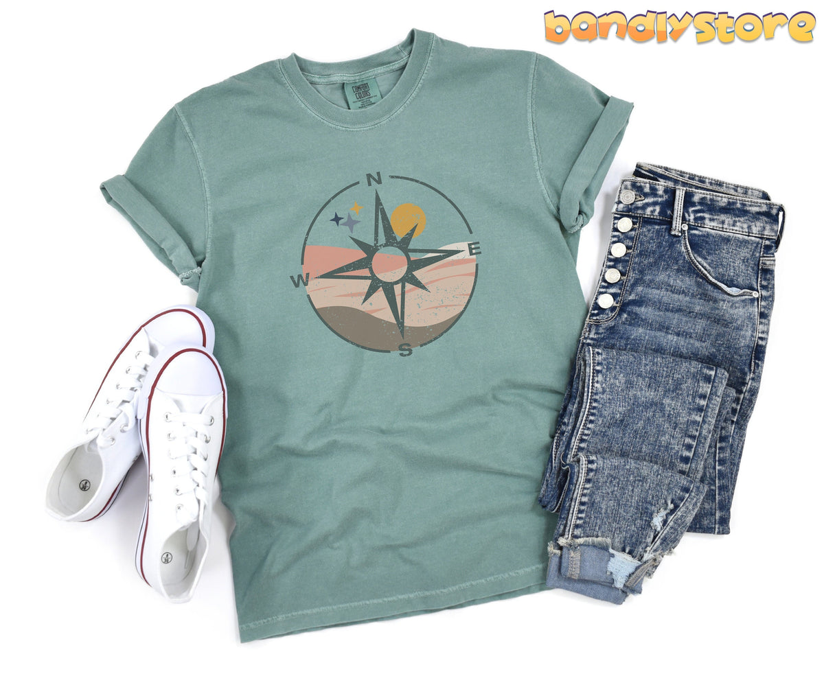 Distressed Compass T-Shirt in Bay, flat-laid with white sneakers left and blue jeans right.