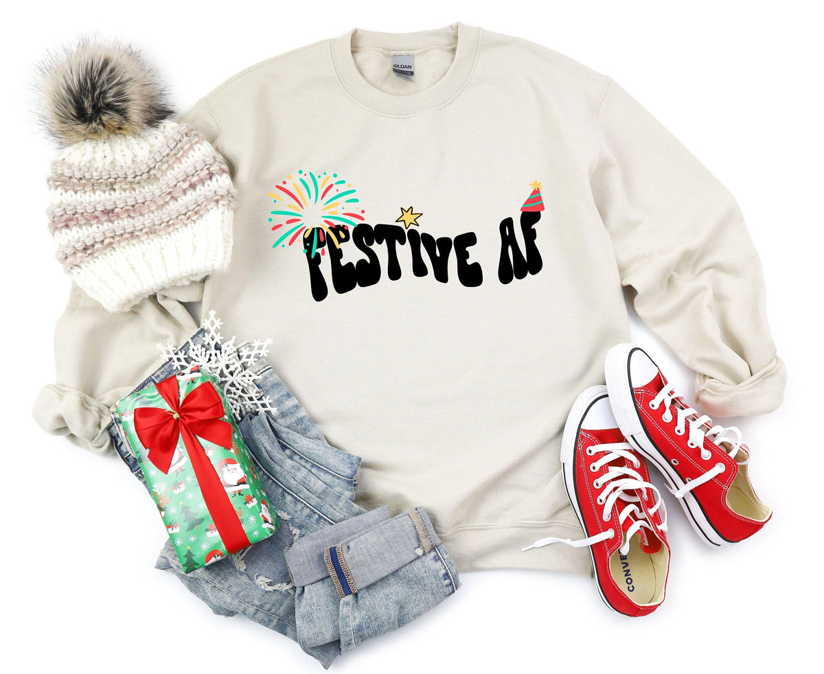 Festive AF Sweatshirt in sand laid flat overhead with beanie, gift, jeans and red sneakers.