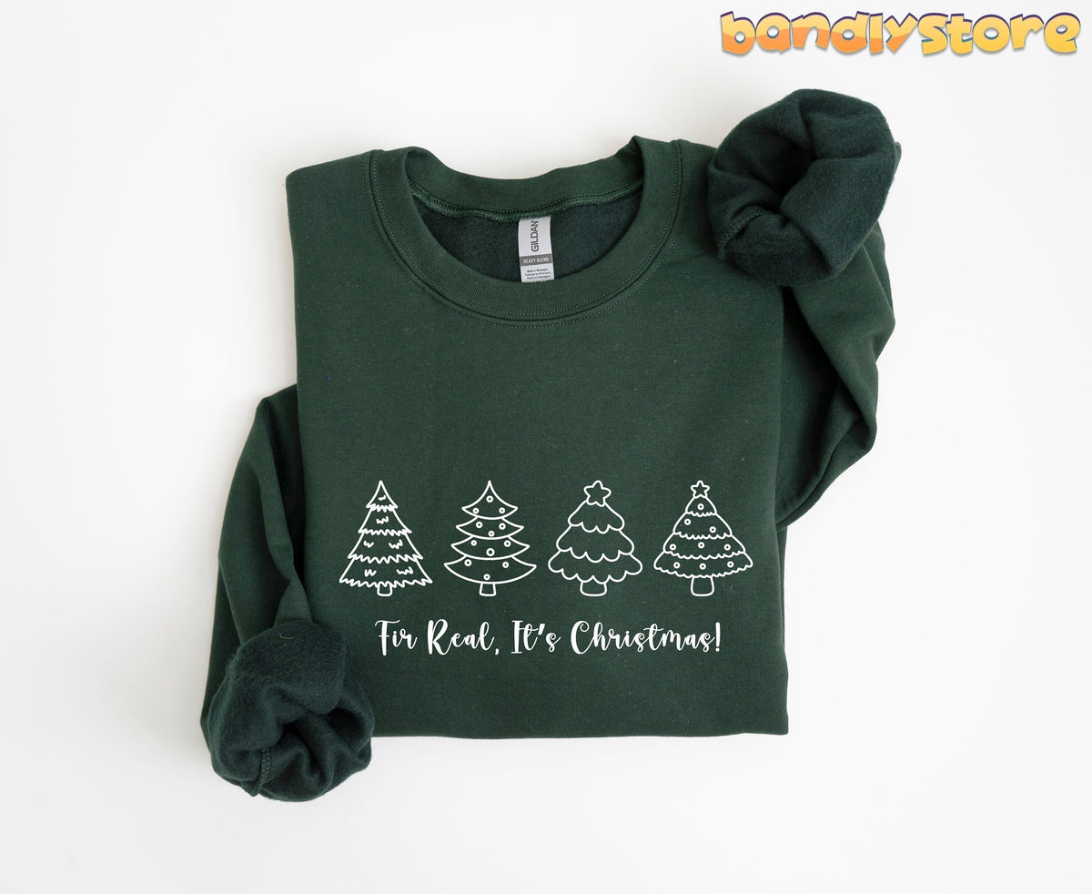 Fir Real It's Christmas Sweatshirt in forest green folded flat on a plain white surface.