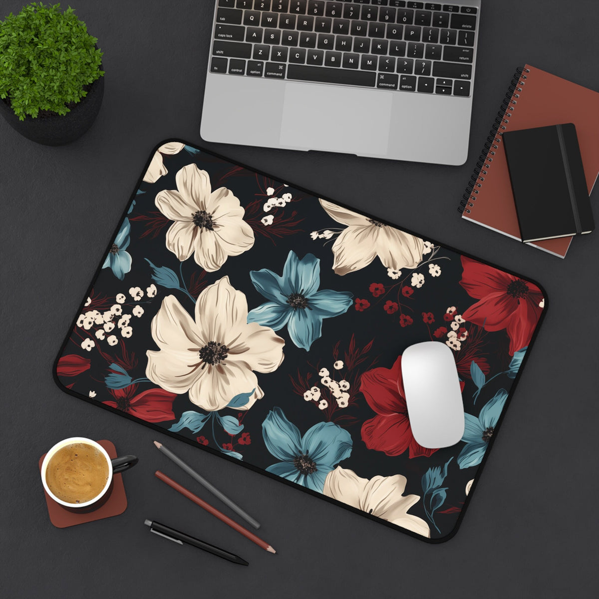 Dark Floral Desk Mat 12 × 18 inches top-down on a desk with laptop, mouse, plant, notebooks, coffee and pencils.