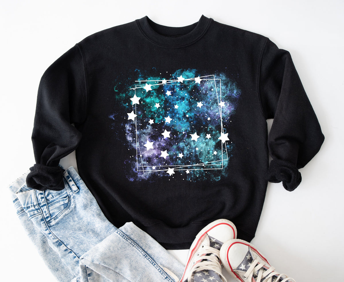 Galaxy Sweatshirt in black laid flat on a white surface with jeans to the left and sneakers below.