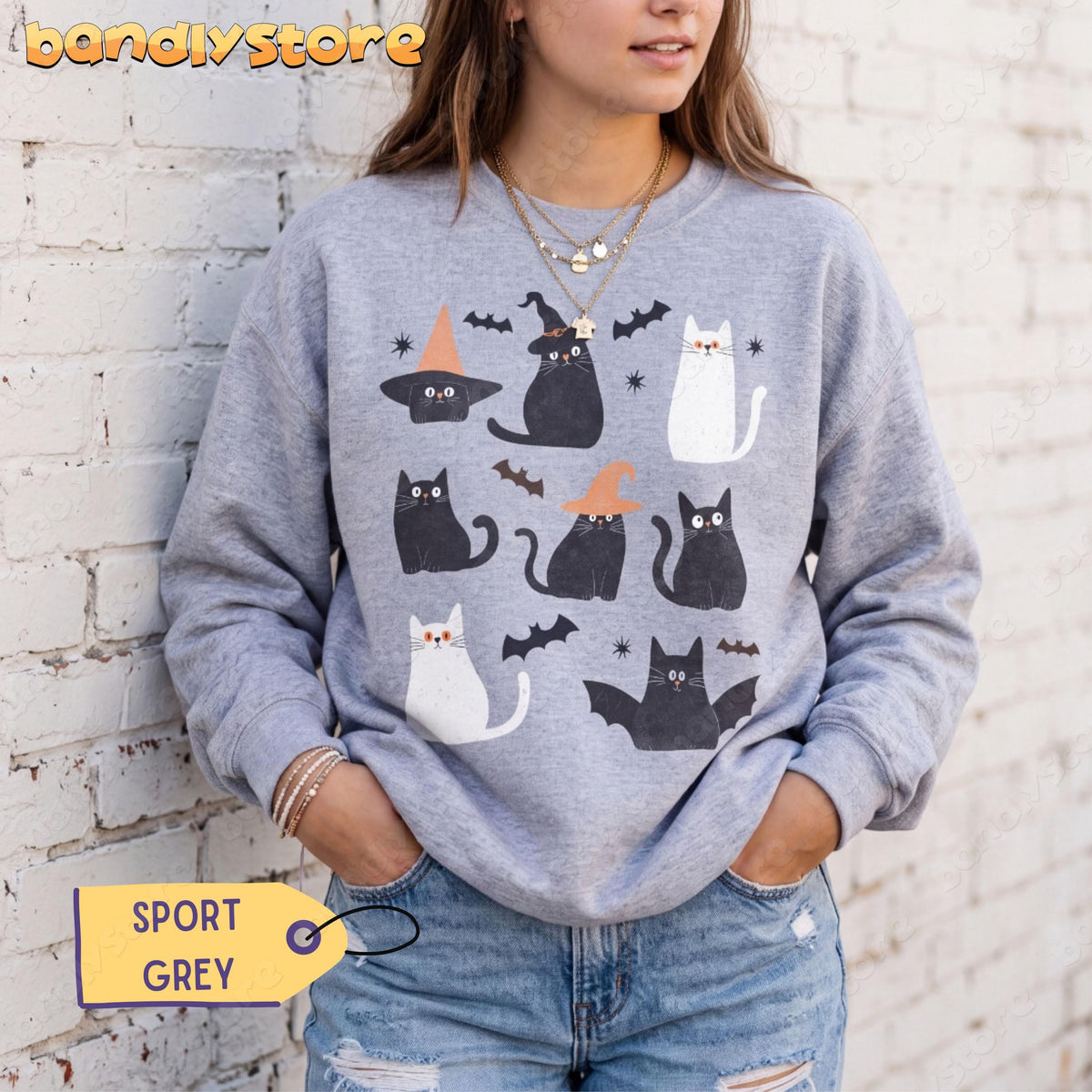 Cute Halloween Black Cat Sweatshirt on a person in Sport Grey against a white brick wall, front view with jeans.