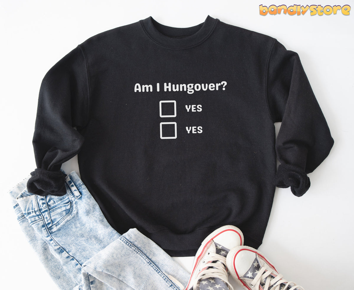 Hangover Sweatshirt in black laid flat on white next to jeans and star sneakers.