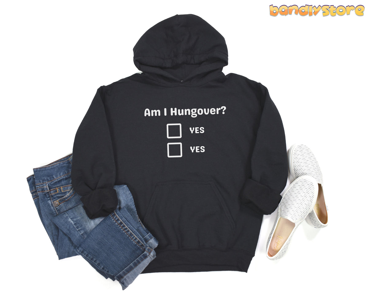Hangover Hoodie in black laid flat from above beside folded jeans and slip-on shoes.