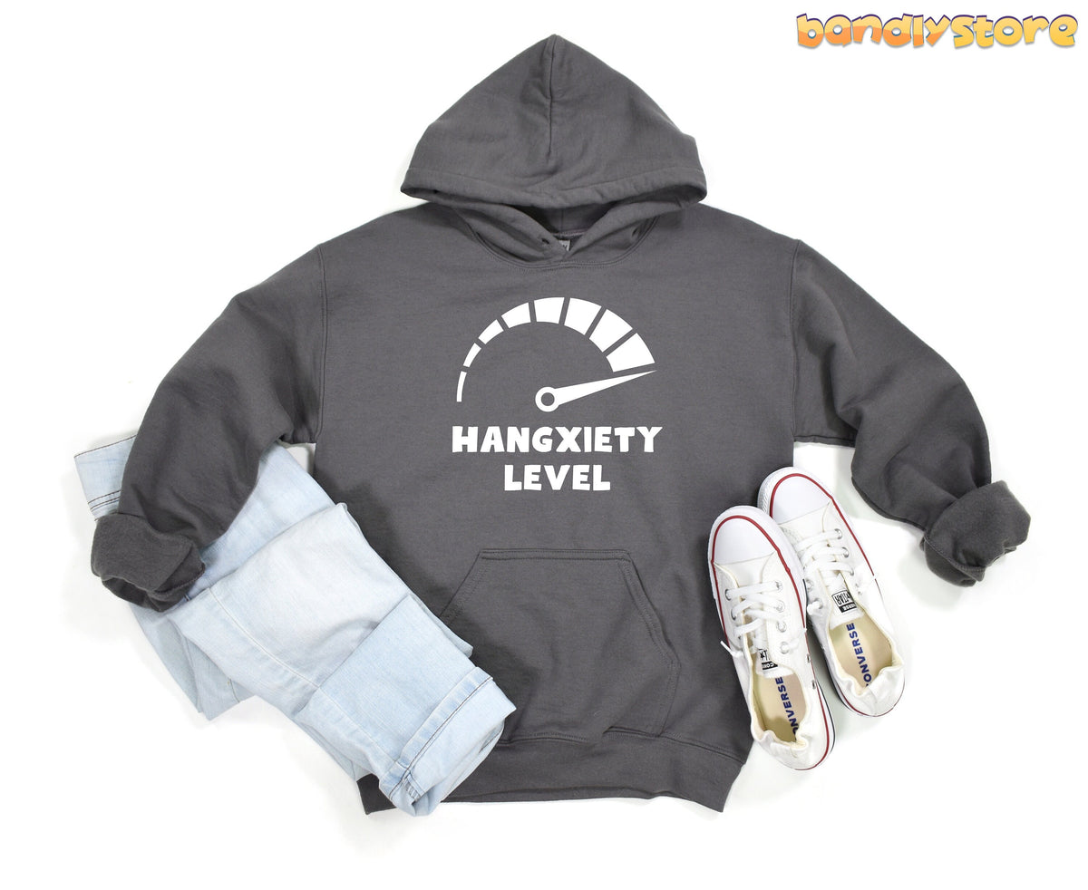 Hangxiety Hangover Hoodie in charcoal laid flat on a white background next to jeans and sneakers.