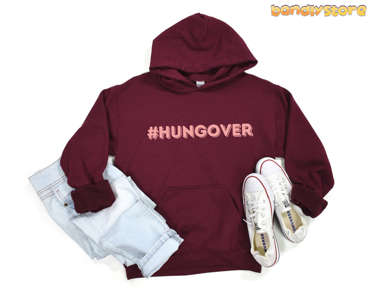 Hashtag Hangover Hoodie in maroon, flat-laid with light jeans left and white sneakers right.