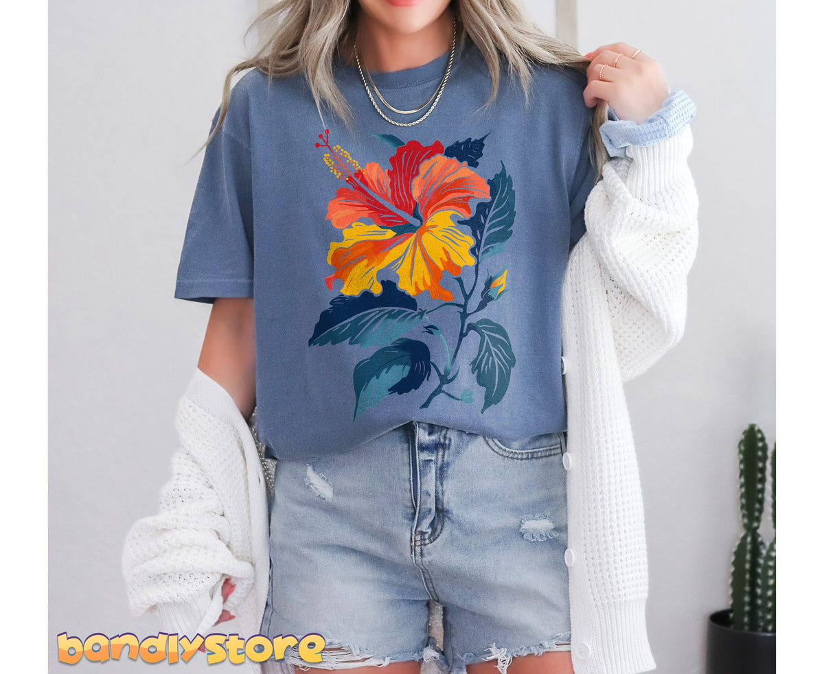 Hibiscus Flower T-Shirt on a model facing forward indoors, white cardigan draped aside and cactus nearby.
