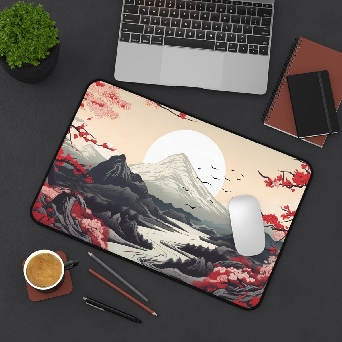 Japanese Mountains Desk Mat top-down on a desk with laptop, plant, coffee, pencils and notebooks, 12 × 18 inches.