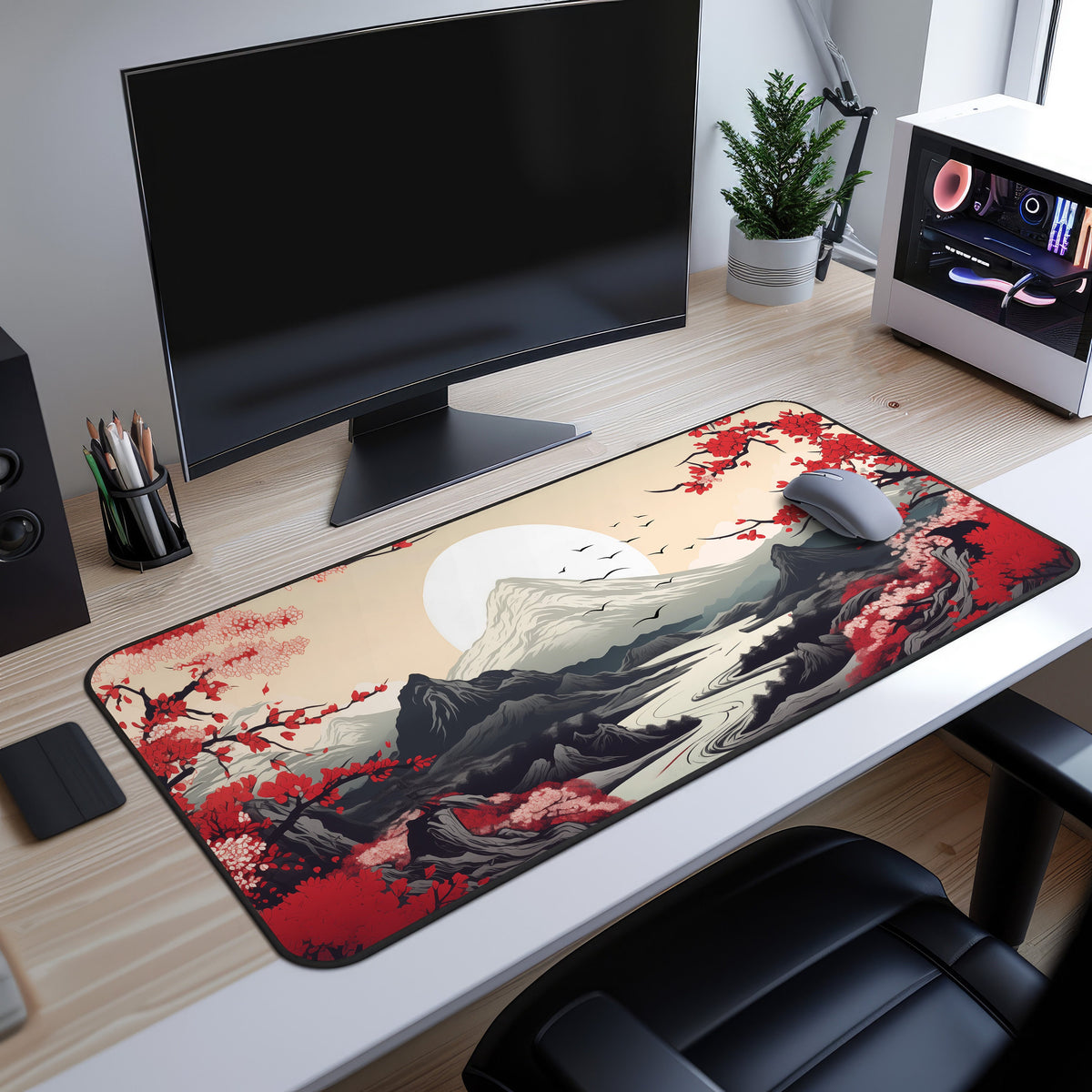Japanese Mountains Desk Mat on a wooden desk under a monitor beside a mouse, plant and PC.