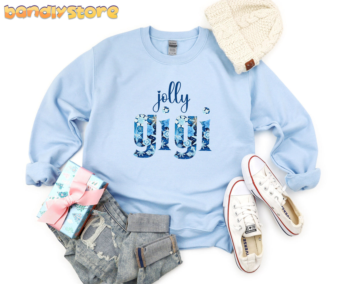 Jolly Gigi Sweatshirt in light blue laid flat beside a beanie, jeans, sneakers and gift box.