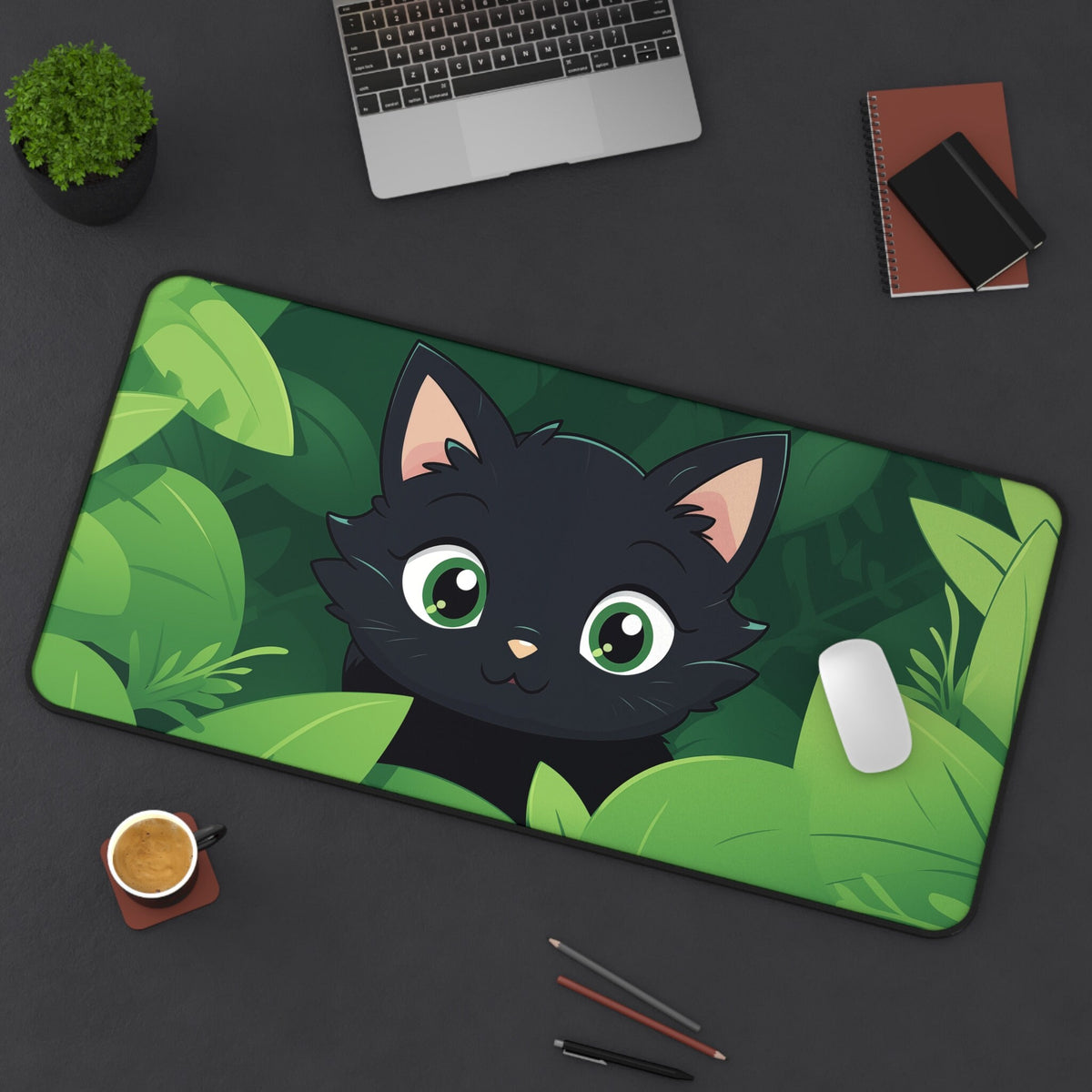 Cute Kawaii Black Cat Desk Mat 16 × 32 inches on a dark desk from above next to laptop, plant, coffee and notebooks.