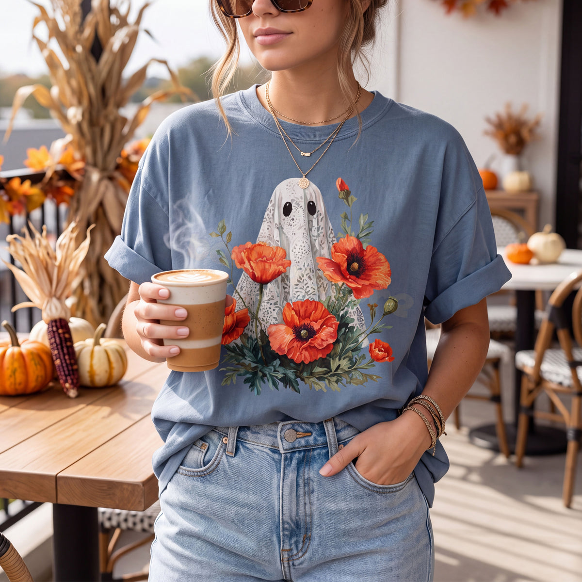 Vintage Lace Ghost Poppies T-Shirt in Blue Jean on a woman holding coffee, front view, fall patio with pumpkins and corn.