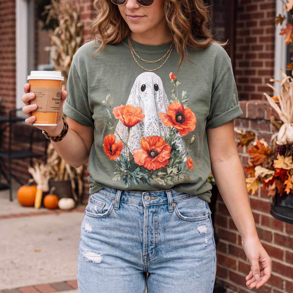 Vintage Lace Ghost Poppies T-Shirt in Moss, worn outdoors by a person holding a pumpkin latte amid autumn porch décor.
