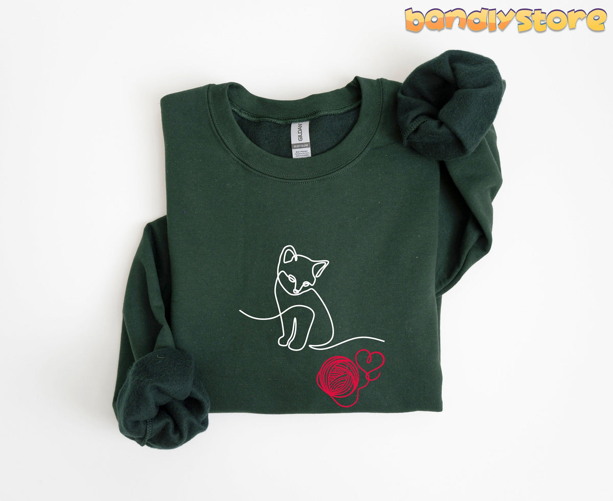 Line Art Kitten Sweatshirt in forest green folded flat on a white background.