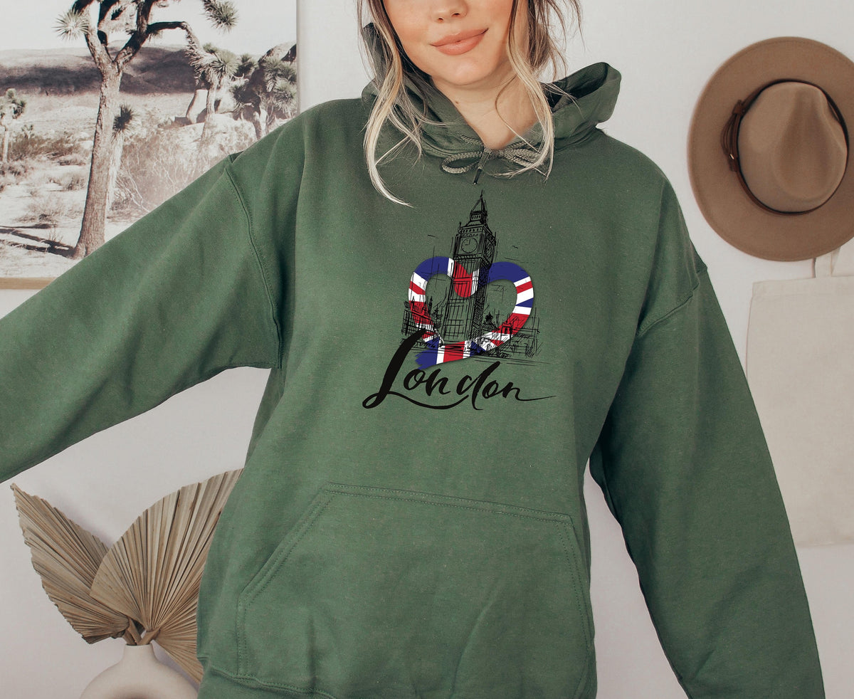 London Big Ben Hoodie in Military Green, worn front-facing with Big Ben heart graphic, desert art and hat behind.