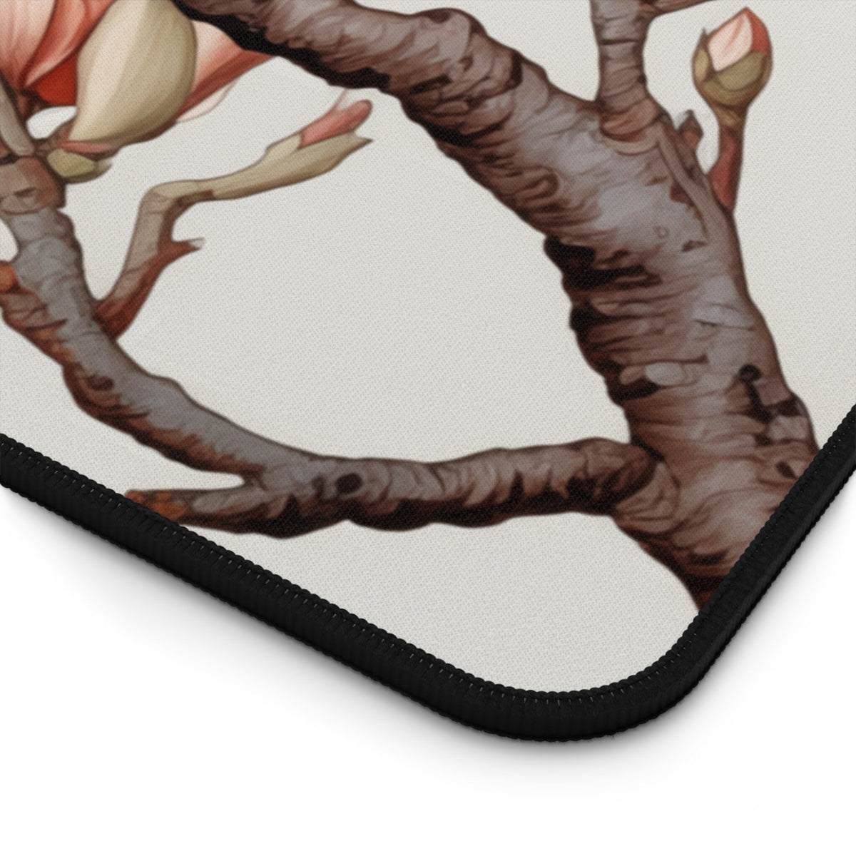 Magnolia Flowers Desk Mat close-up corner detail with branches, buds and black stitched edge.