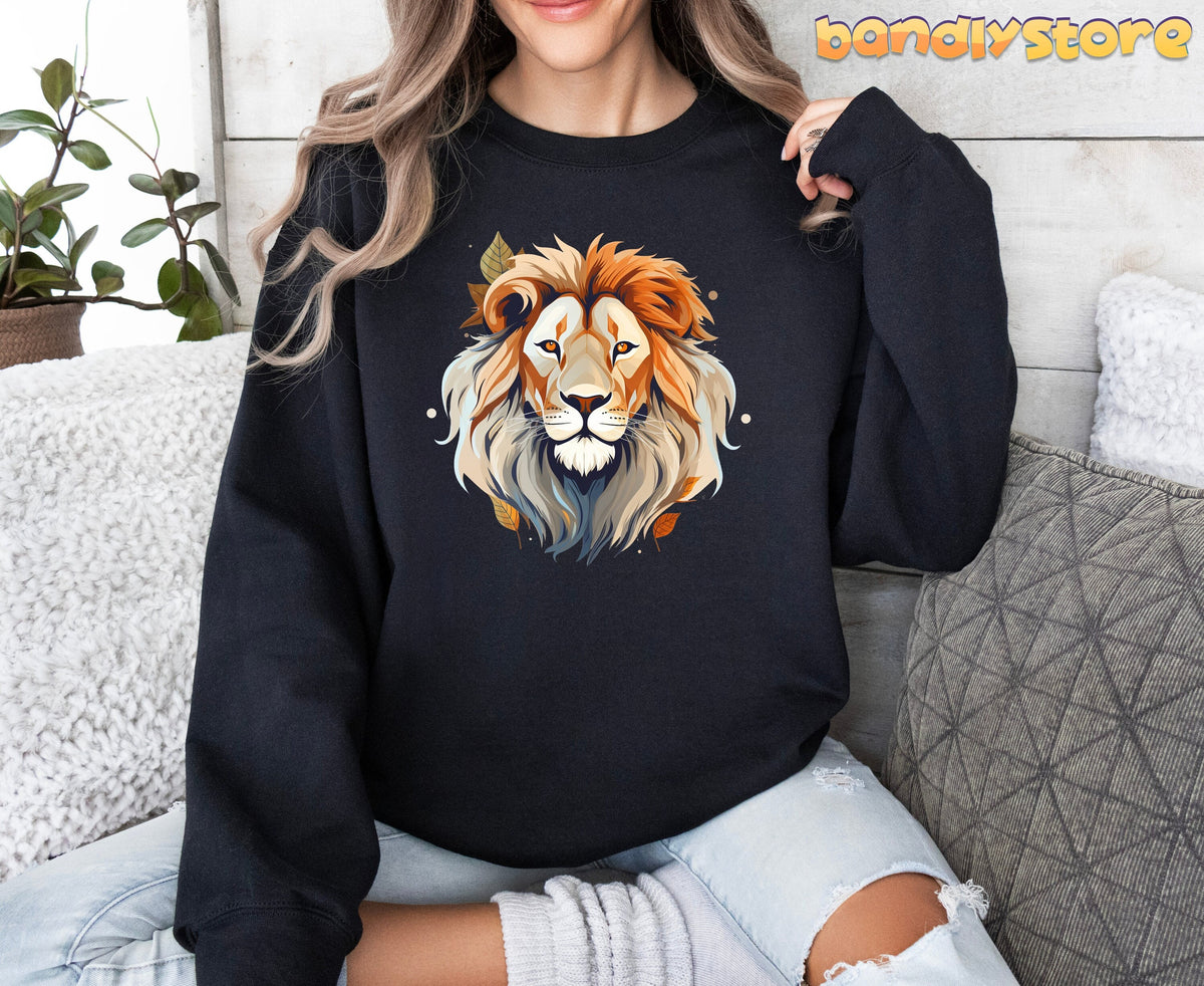 Majestic Lion Sweatshirt in black on a woman seated indoors amid plants and pillows, front view.