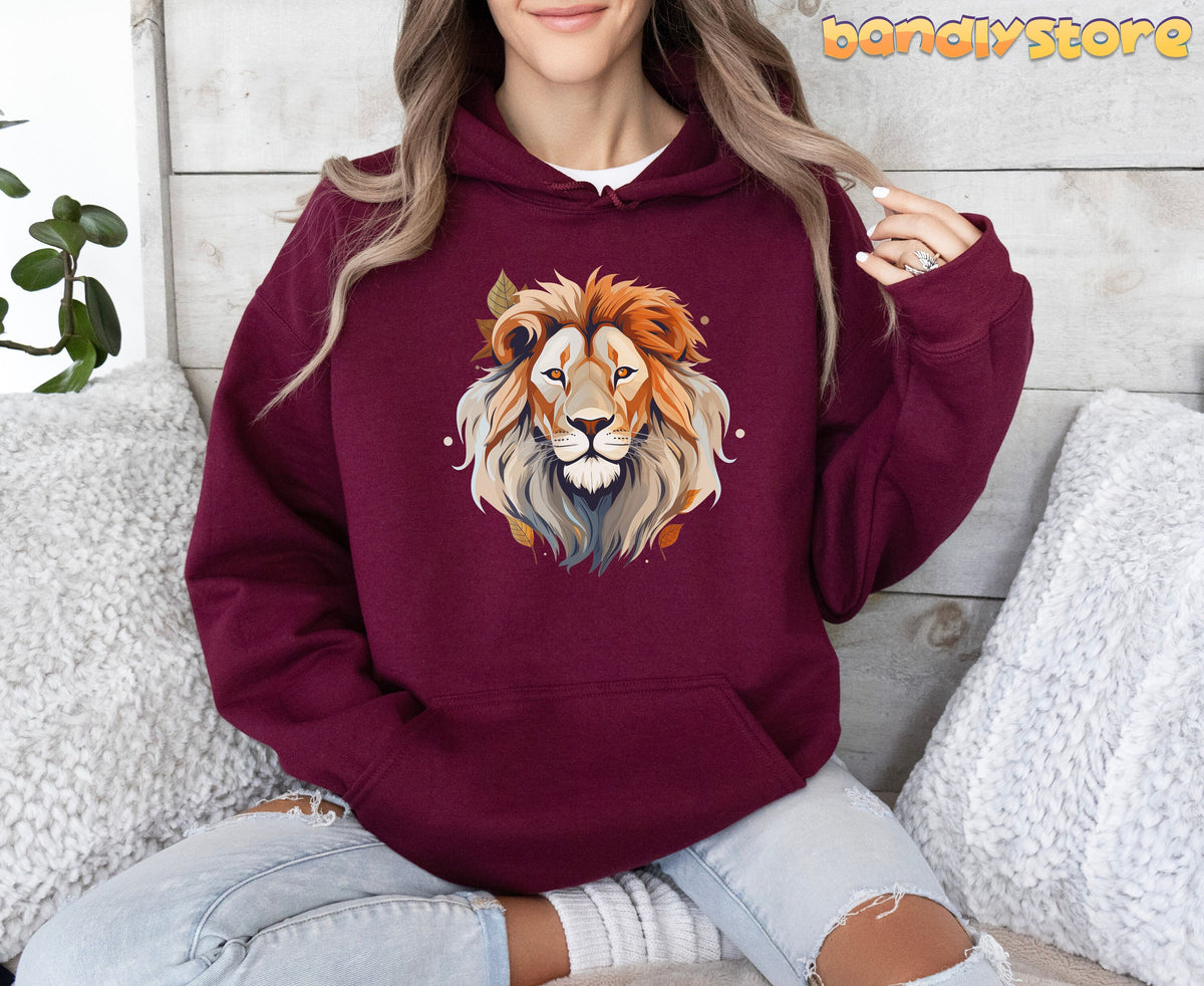 Majestic Lion Hoodie in maroon on a seated person, front view amid white pillows, plant and wood wall.