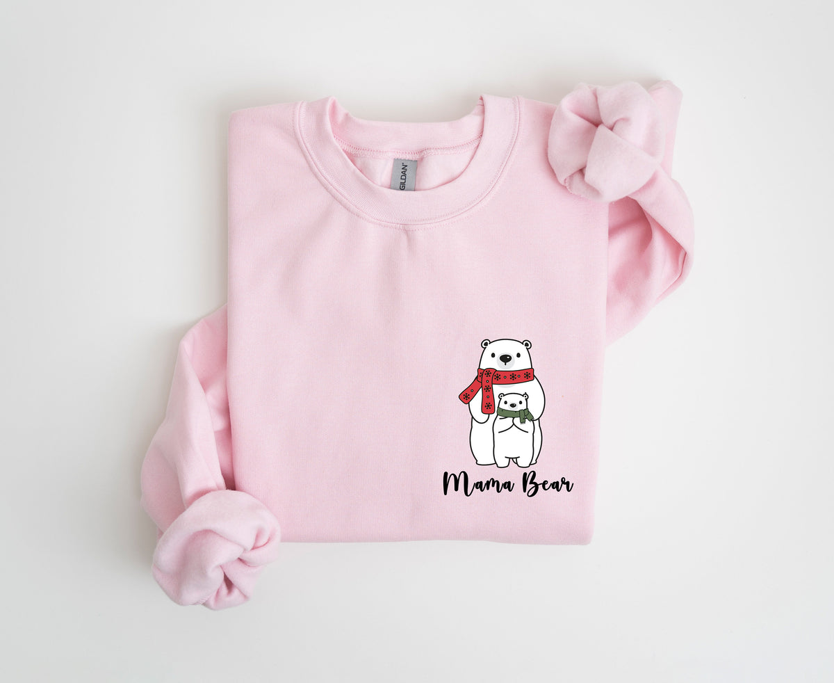 Pocket Mama Bear Sweatshirt in light pink, folded flat on white with mama and cub graphic on the lower right.