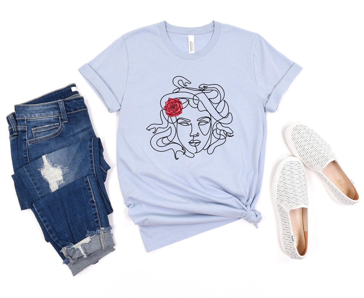 Medusa Head T-Shirt in light blue laid flat beside ripped jeans and striped slip-on shoes.