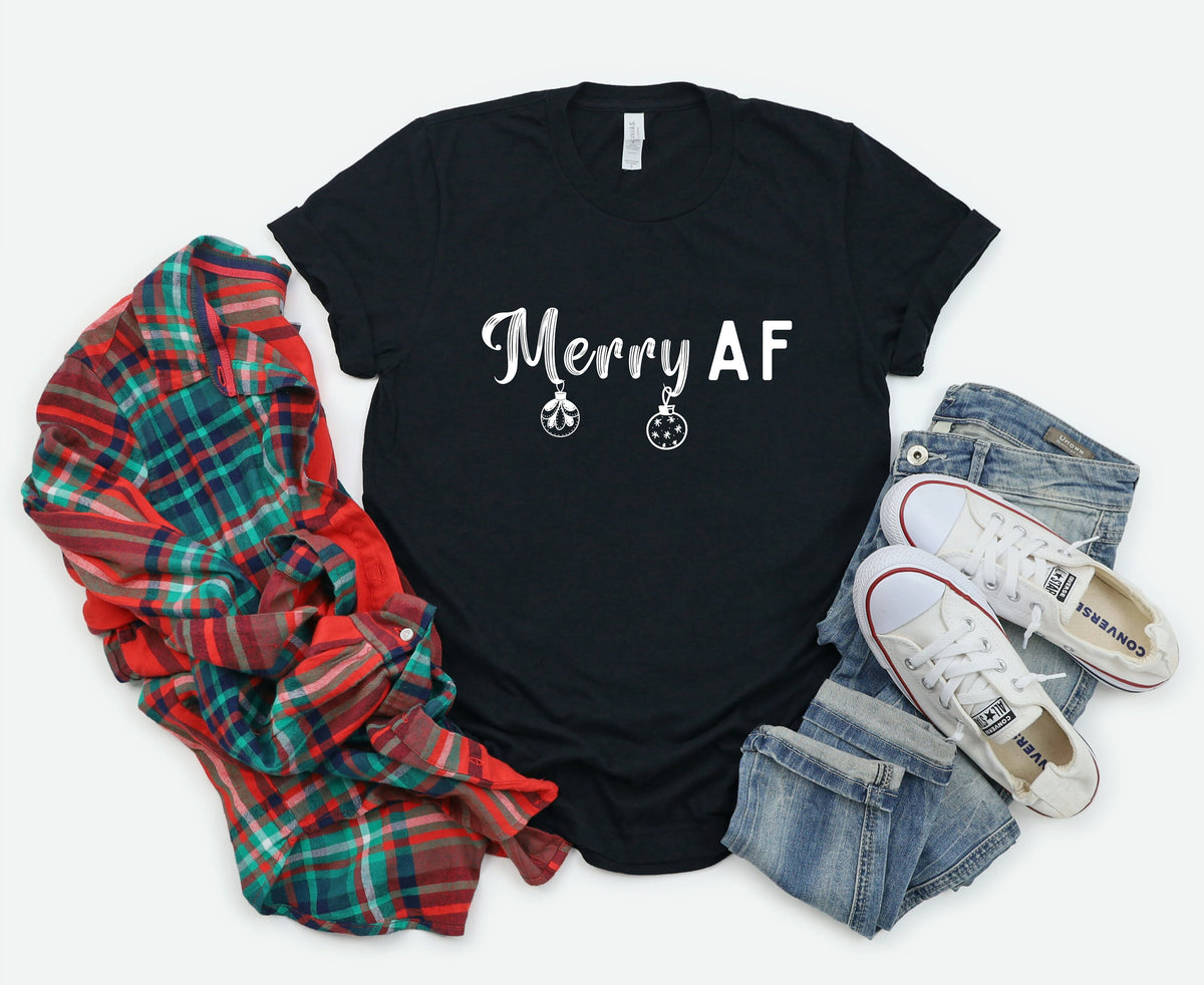 Merry AF T-Shirt in black flat-laid beside a plaid flannel, jeans and sneakers.