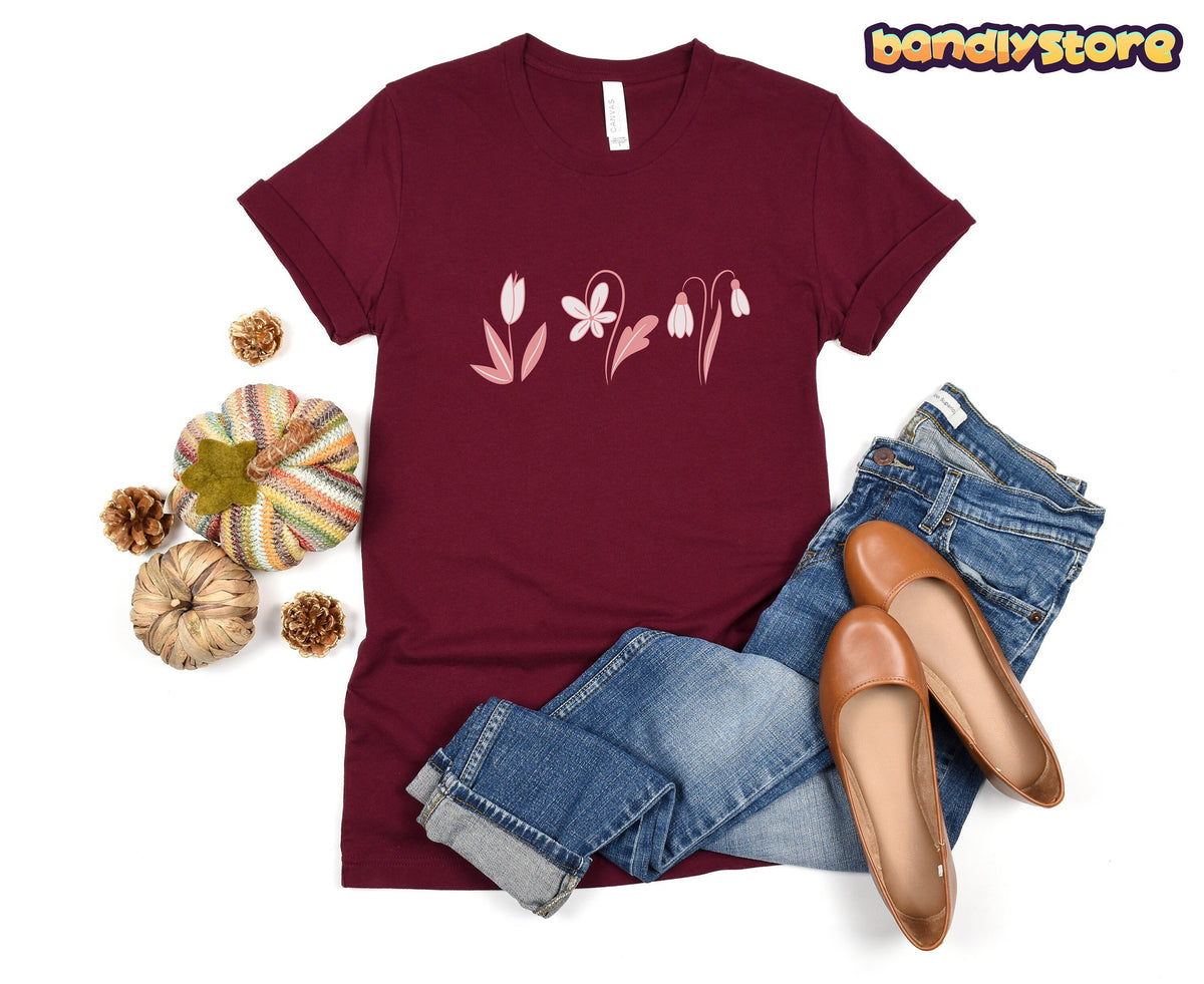 Monochromatic Spring Flowers T-Shirt flat-laid beside knit pumpkins, pinecones, blue jeans and brown flats.