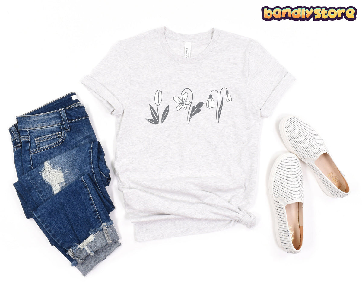 Monochromatic Spring Flowers T-Shirt in ash in a top-down flat lay with blue jeans and white slip-ons.