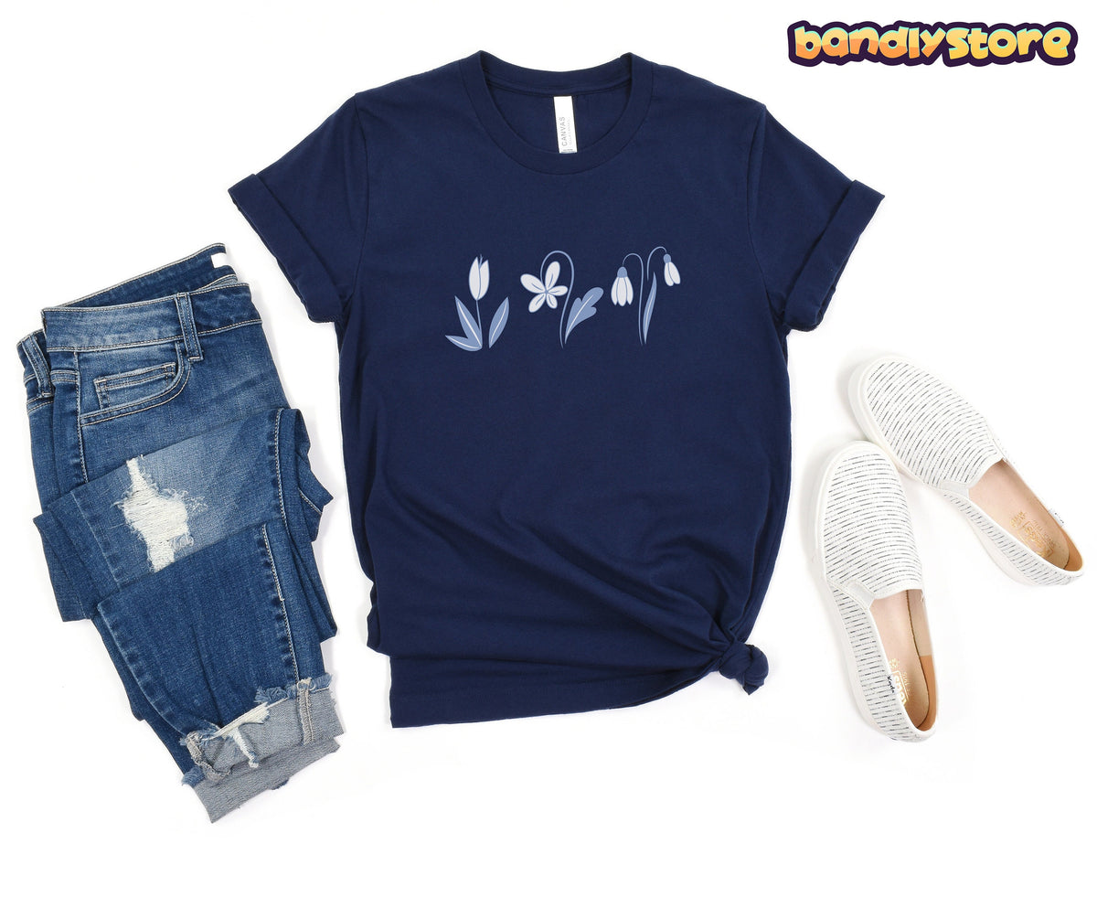 Monochromatic Spring Flowers T-Shirt in navy flat-laid beside ripped jeans and white slip-on shoes.