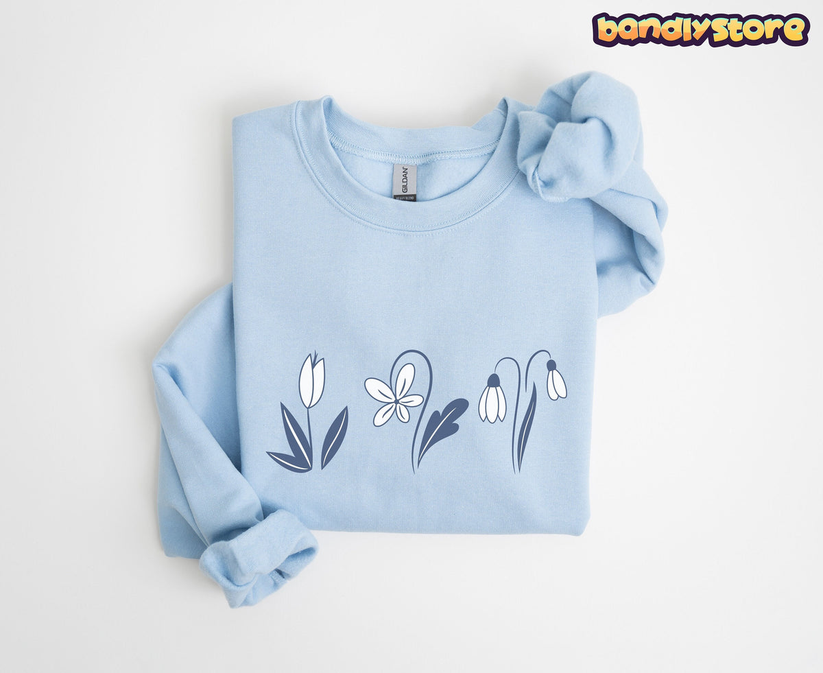 Monochrome Spring Flowers Sweatshirt in light blue folded flat on a plain white background viewed from above.