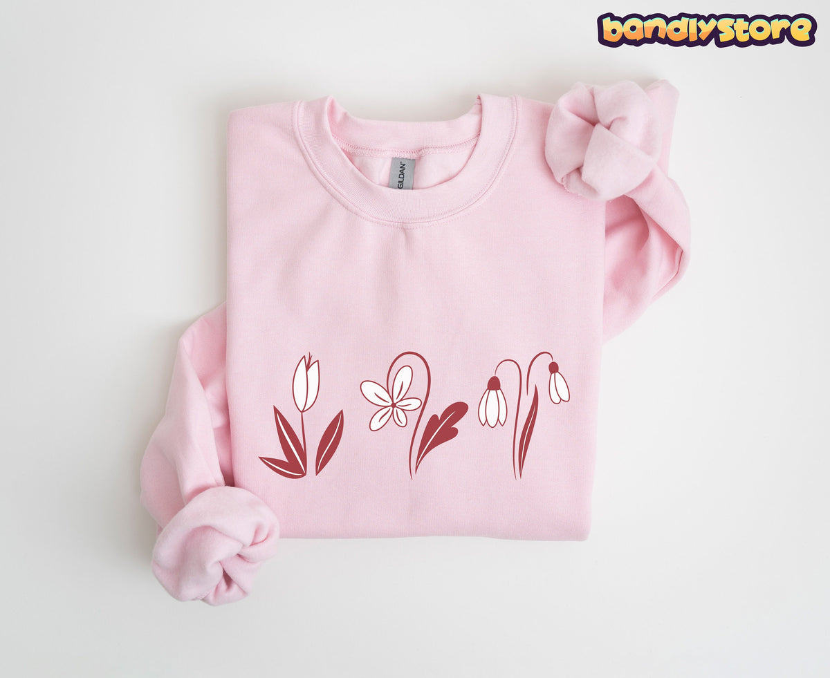 Monochrome Spring Flowers Sweatshirt in light pink, folded flat on white with maroon line-art blooms across the chest.