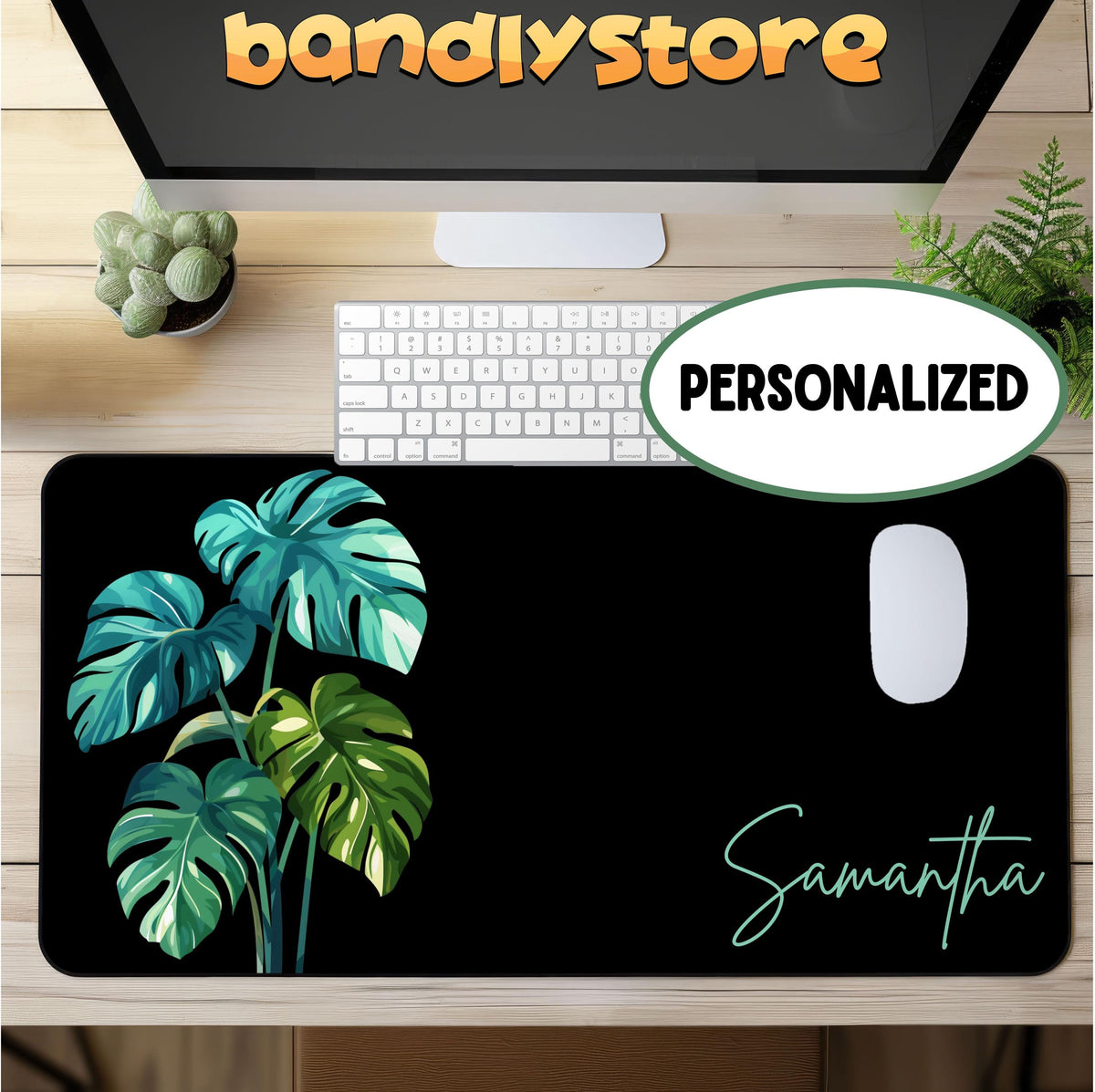 Personalized Monstera Desk Mat on wooden desk from above with keyboard, mouse, monitor and plants.
