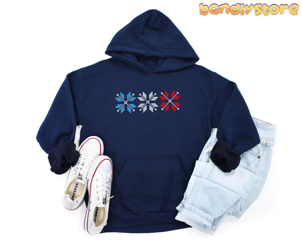 Old Fashioned Snowflake Hoodie in navy, laid flat with white sneakers left and light jeans right.