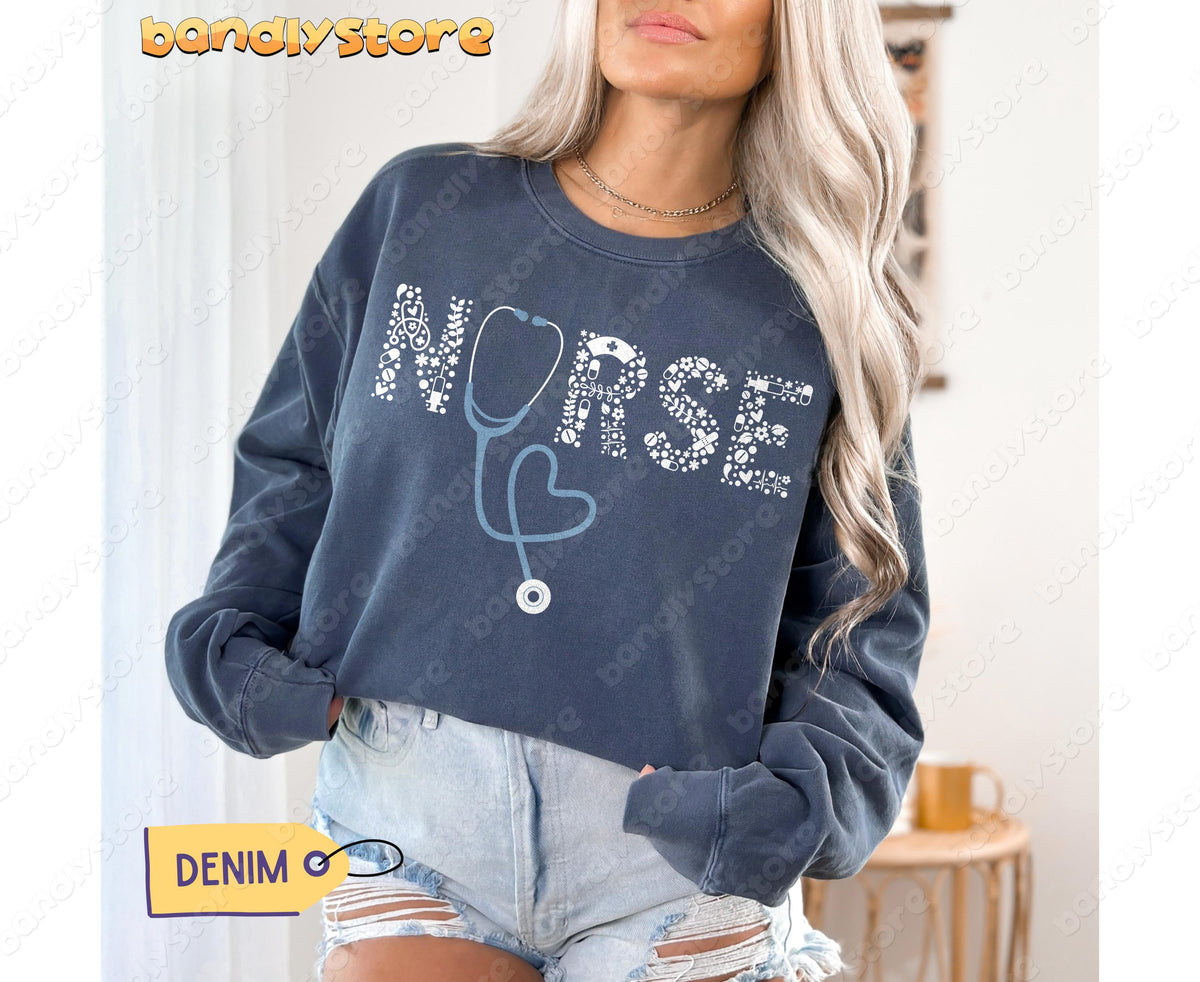 Personalized Nurse Sweatshirt in denim on a model facing forward indoors, hands in pockets beside a side table.
