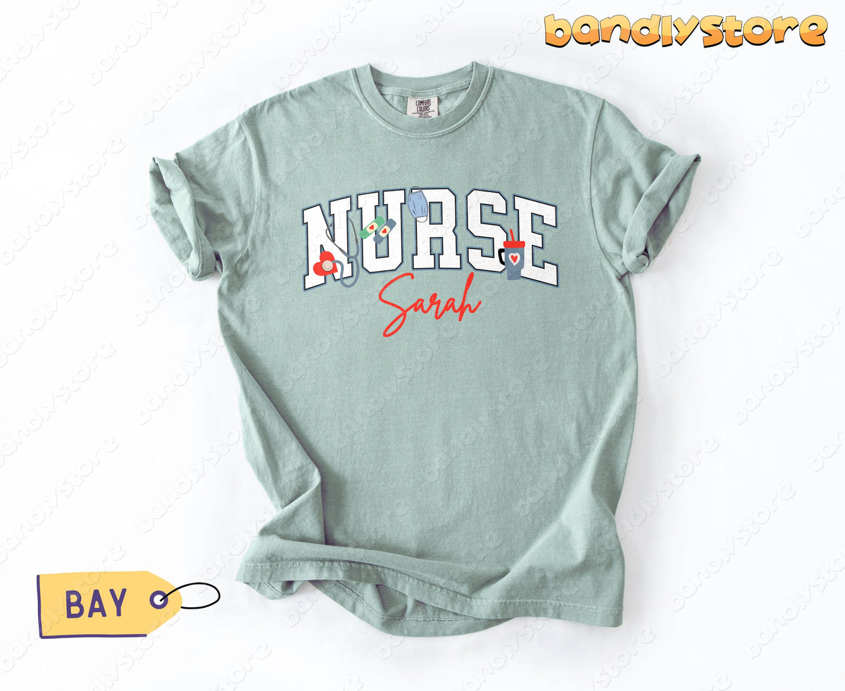 Personalized Nurse T-Shirt in Bay laid flat on a white surface beside a yellow Bay tag.