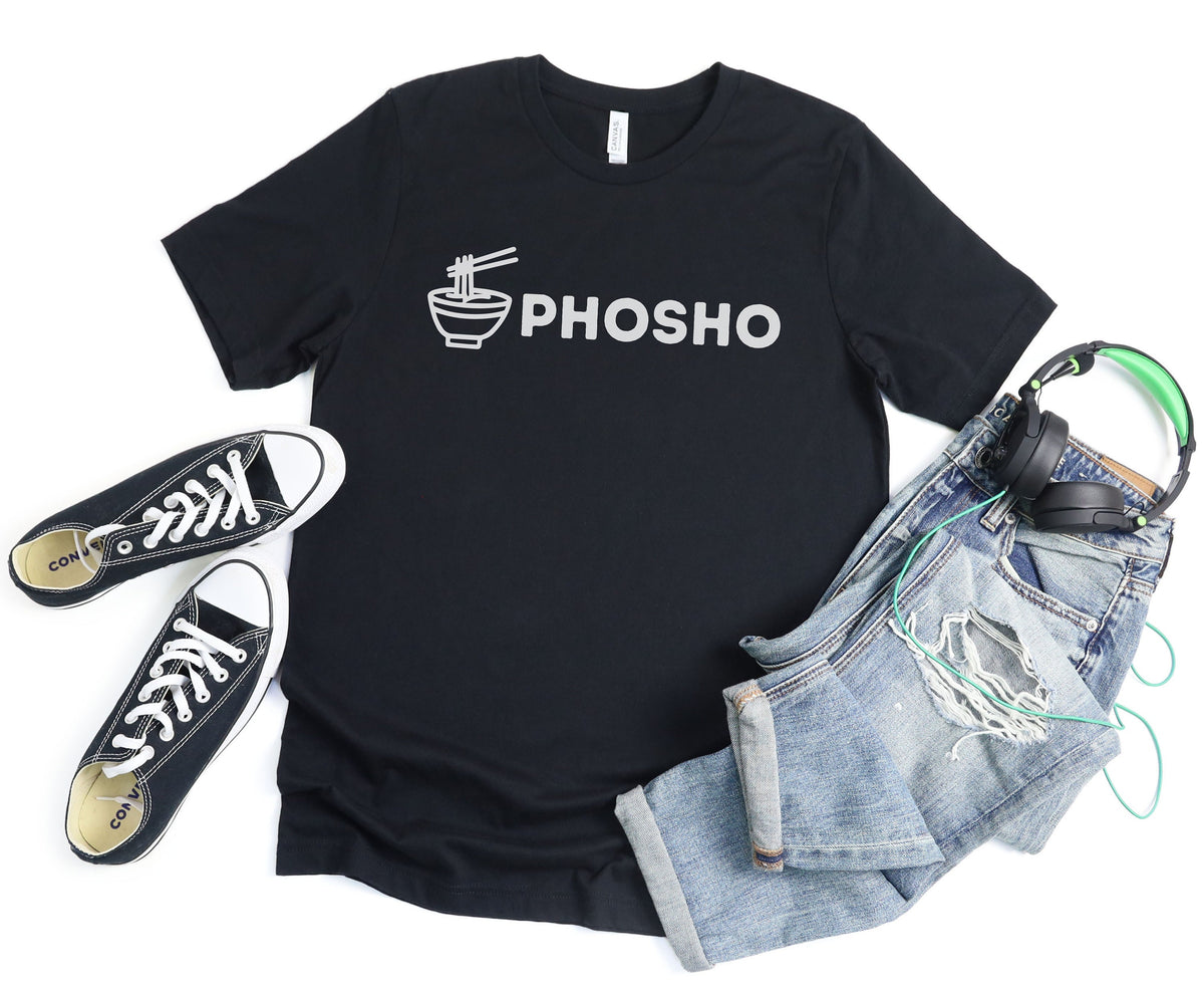 Pho Sho T-Shirt in black laid flat on white beside sneakers, ripped jeans and headphones.