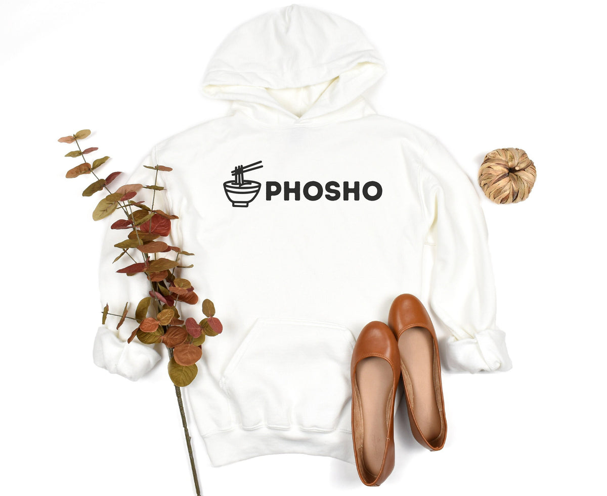 Pho Sho Hoodie in white laid flat beside autumn foliage, brown flats and a woven ball.
