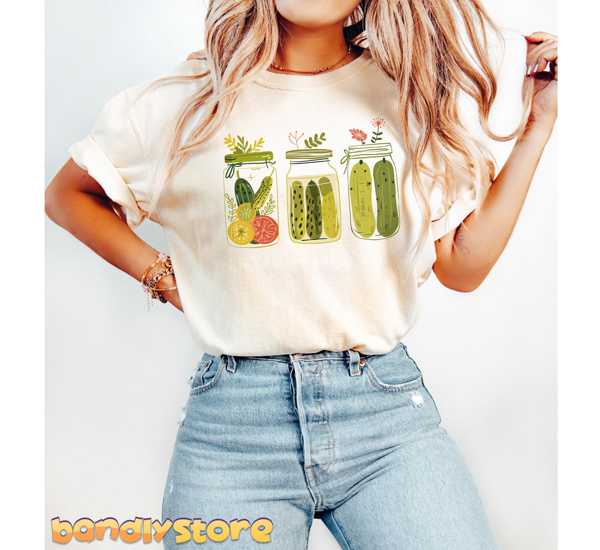 Pickle Jars T-Shirt in ivory, worn by a person standing front-on with three illustrated pickle jars across the chest.