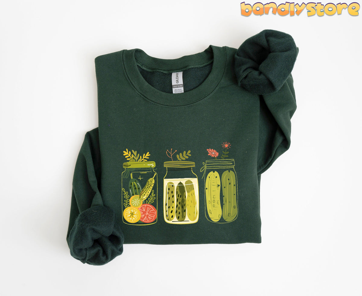 Pickle Jars Sweatshirt in forest green, folded flat on white with three illustrated pickle jars across the chest.
