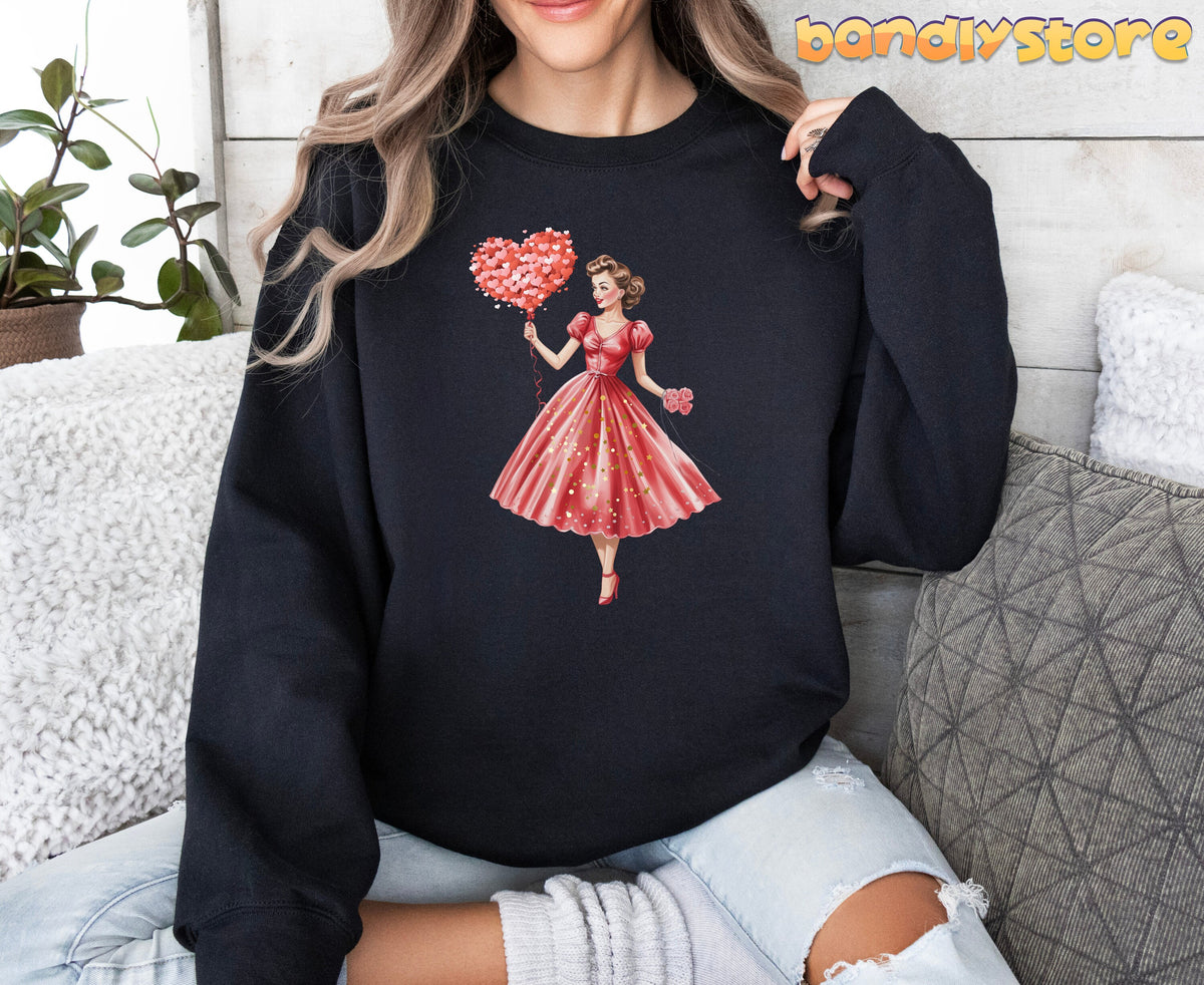Cute Valentine Girl Sweatshirt in black on a seated model amid pillows and a potted plant.