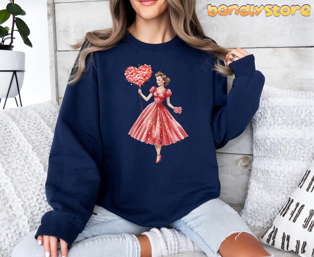 Cute Valentine Girl Sweatshirt in navy, worn front-facing by a seated model amid pillows, plant and wood wall.