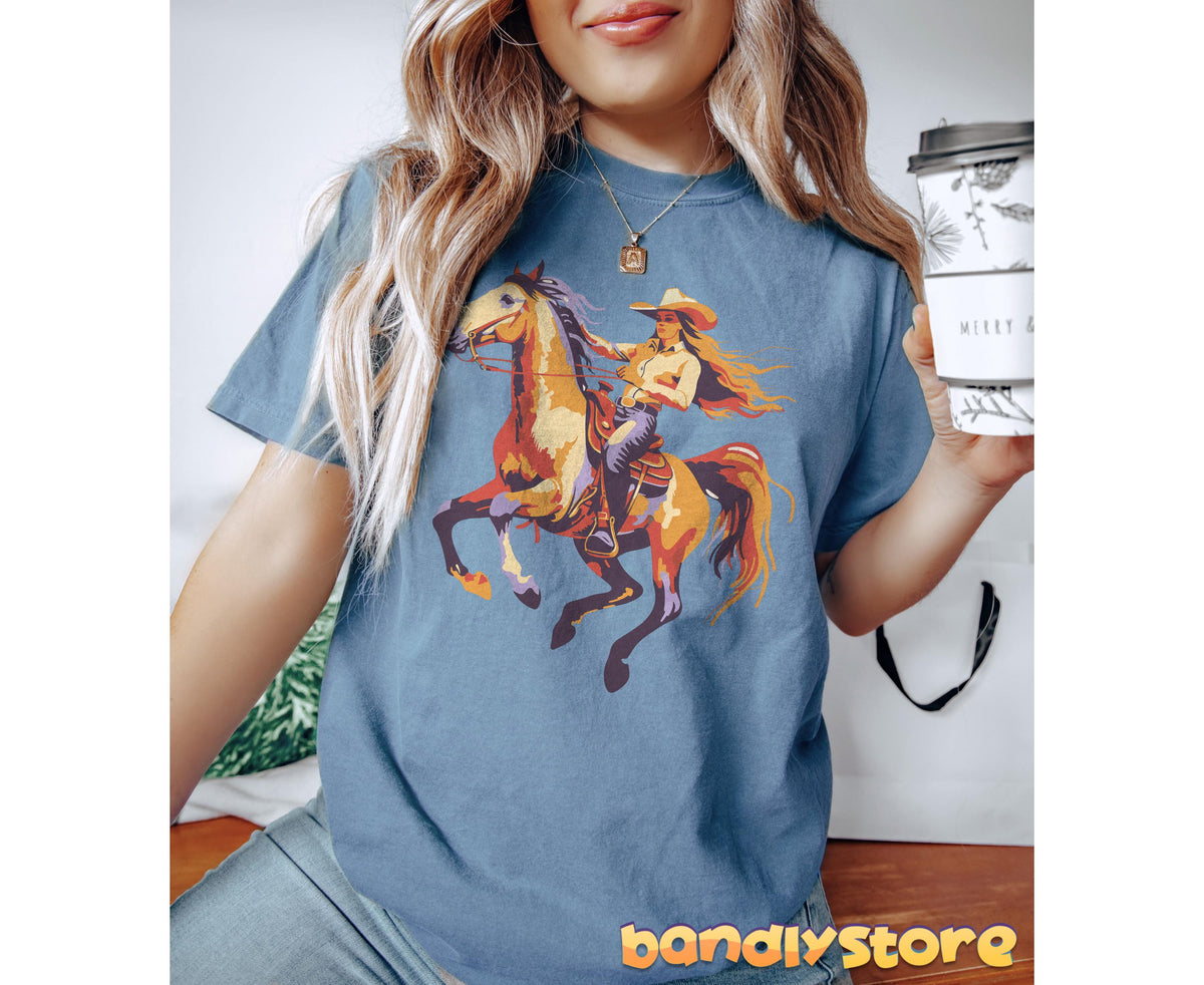 Retro Yeehaw Cowgirl T-Shirt in Blue Jean on a woman seated holding a coffee cup indoors.