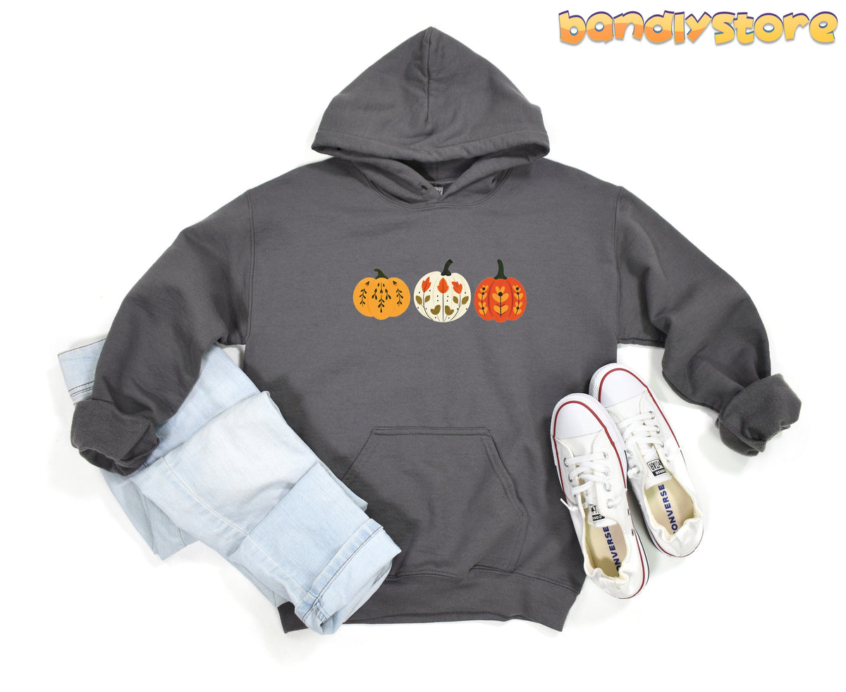 Scandinavian Art Pumpkin Hoodie in charcoal, flat-laid with jeans left and white sneakers right.
